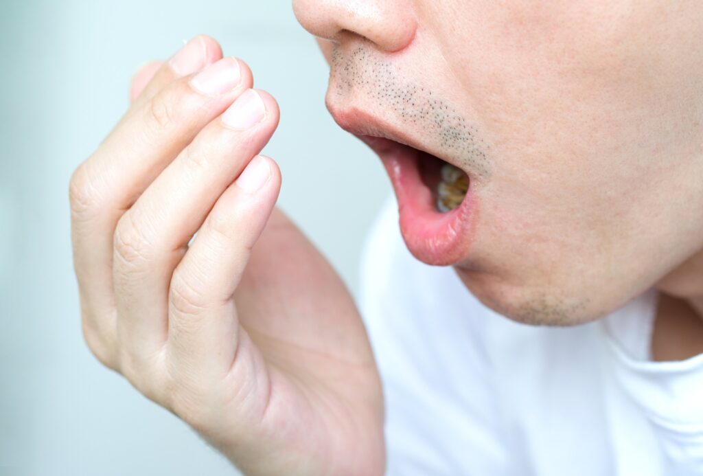 Person covering mouth due to bad breath at Mary St Dental Gympie