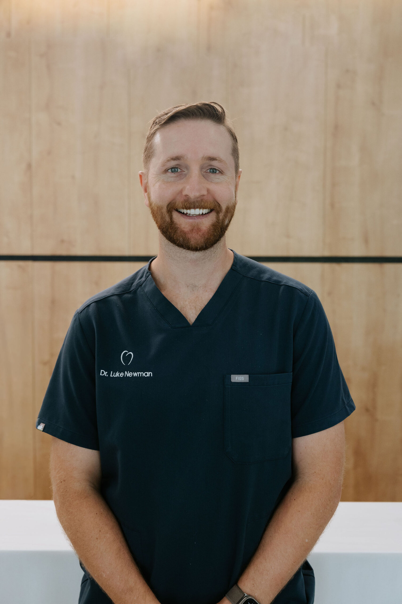 Professional headshot of Dr. Luke Newman, dentist at Mary St Dental Gympie, smiling in medical attire.