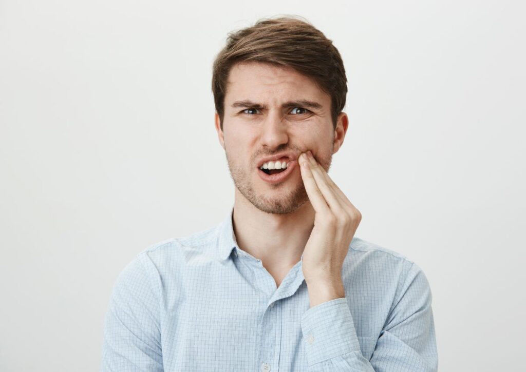 Man experiencing tooth pain from a cracked tooth needing dental treatment in Gympie